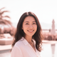 Close-up portrait of a smiling East Asian woman, radiating happiness and satisfaction on a bright summer day.
